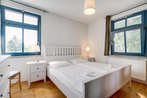 朗克维茨3-Raum Familienapartment bis 4 Pers 53的卧室配有白色的床和2扇窗户。