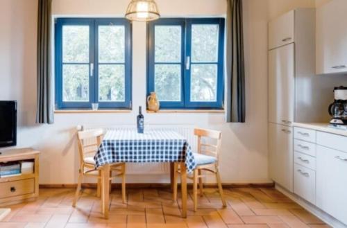 朗克维茨2-Raum Apartment bis 4 Pers 32的厨房配有桌椅和蓝色窗户。