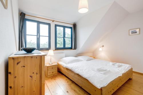 朗克维茨2-Raum Apartment bis 4 Pers 32的一间卧室配有一张带白色床单的木床