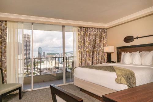 檀香山威基基温德姆皇家花园度假酒店的酒店客房设有一张床和一个阳台。