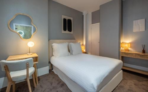 巴黎Makom Pereire的一间卧室配有一张床、镜子和椅子