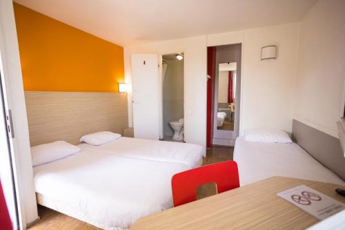 瑟堡普瑞米尔希尔伯格图尔拉维拉经典酒店的酒店客房设有两张床和一张桌子。