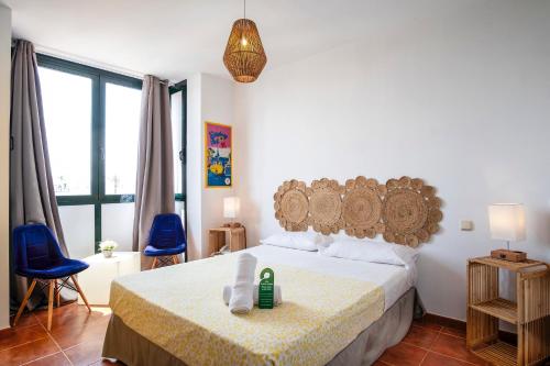 Estepona马蒂尔德夫人酒店的一间卧室配有一张床和两张蓝色椅子