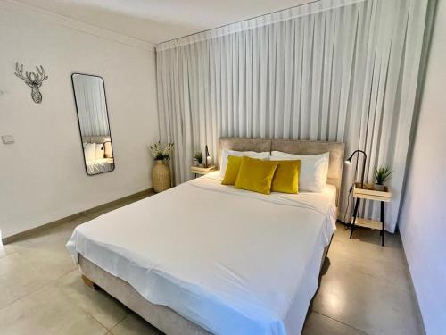 舍亚尔雅舒弗Orhan Havaya的卧室配有一张带黄色枕头的大型白色床。