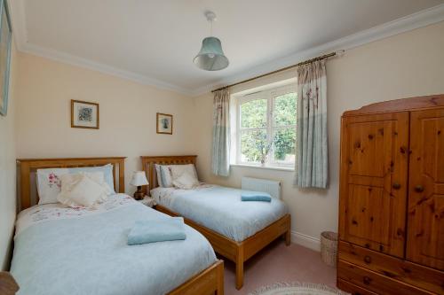 BoldreOak Tree Cottage, Charming, Rural New Forest Home的一间卧室设有两张床和窗户。