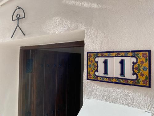 格拉纳达Apartamentos Indalo a los pies del Albaicín的挂在墙上的11号标志
