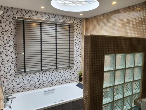 Ban PhalaGrace Seaview บ้านพักส่วนตัว 3 ห้องนอน วิวทะเล หาดพลา的带浴缸的浴室和窗户。