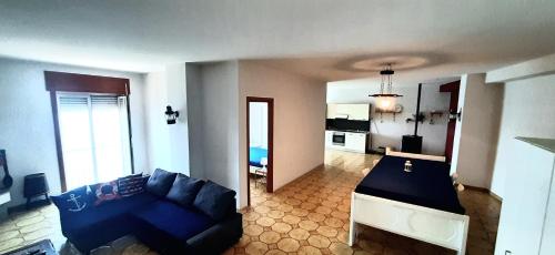 巴科利Castello Apartment的一间带蓝色沙发的客厅和一间厨房