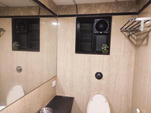 索拉普Hotel Vaishnavi的浴室的墙上设有2个扬声器,还设有2个卫生间