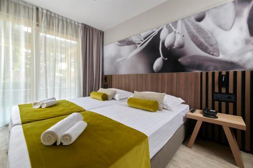 乌马格Residence Garden Istra Plava Laguna的一间卧室配有一张大床和毛巾