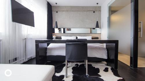 雷克雅未克Thingholt by Center Hotels的一间卧室配有一张带桌子和椅子的床