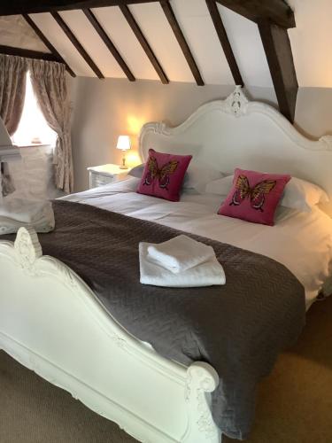 巴斯洛1A River Cottage的卧室配有带粉红色枕头的大型白色床