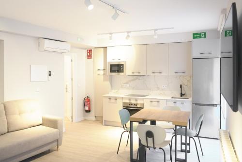 布尔戈斯APARTAMENTOS LA FLORA BURGOS todos con aire acondicionado y ascensor的厨房以及带桌椅的用餐室。