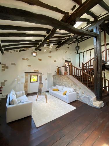 HermosaPosada La Lomba的客厅设有2张白色沙发和楼梯
