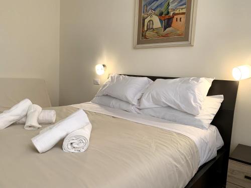 TerralbaDomo Achenza的一张带白色枕头的床和毛巾