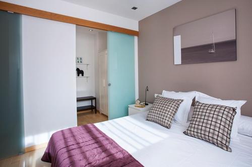 巴塞罗那杜莱特兰布拉玛公寓的卧室配有白色的床和2个枕头