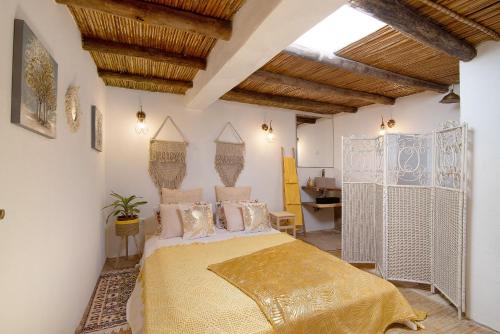 塔维拉Quinta do Silêncio T4的一间带一张床的卧室,位于带木制天花板的房间内