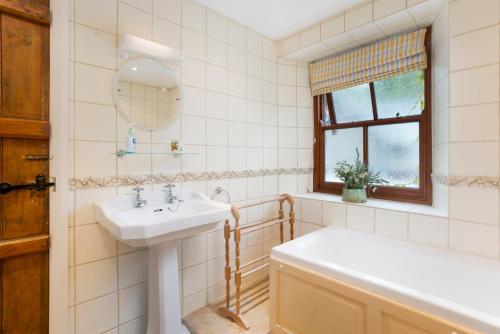安布尔塞德Old Sawpit的一间带水槽、浴缸和镜子的浴室