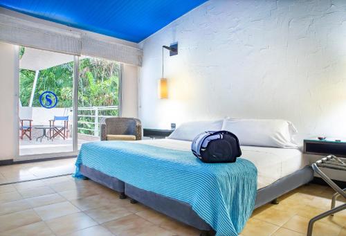 圣玛尔塔圣拓利尼精品酒店 的一间卧室,床上有背包