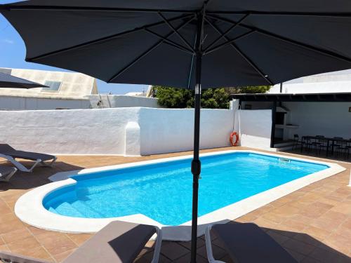 纳萨雷特Nazaret Villa with heated pool的游泳池旁的一把黑伞