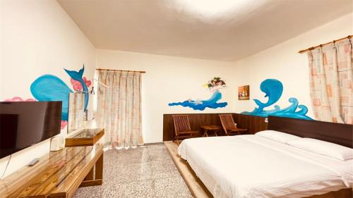 小琉球岛大峰民宿的一间卧室配有一张床和一台平面电视