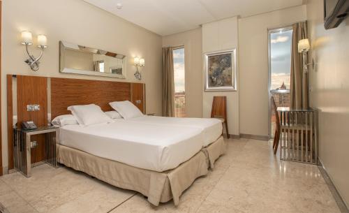 萨拉曼卡科隆纳索尔大酒店的卧室配有一张白色大床和镜子