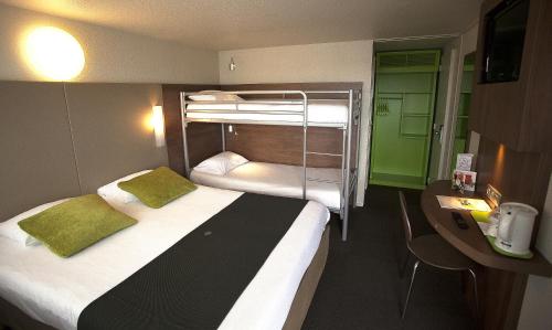 布尔日钟楼布尔杰北圣杜夏尔酒店的酒店客房设有两张双层床和一张书桌。