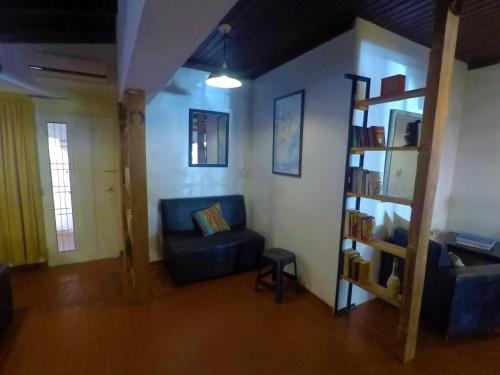 伊瓜苏港Cataratas Jazz Hostel的客厅设有蓝色的沙发和书架
