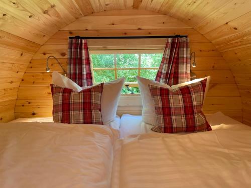 蒂门多弗施特兰德Timmi Lake的一张带两个枕头的床和一个窗户