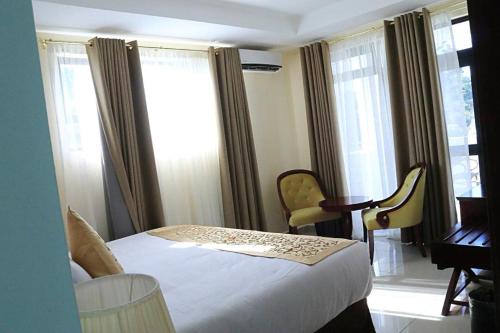 姆巴巴内Open House Hotel的卧室配有一张床、一张书桌和窗户。