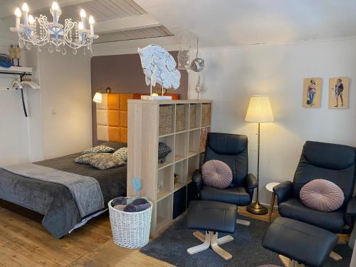 赫尔Vakantiehuisje De Waterhoek的一间卧室配有一张床和两把椅子