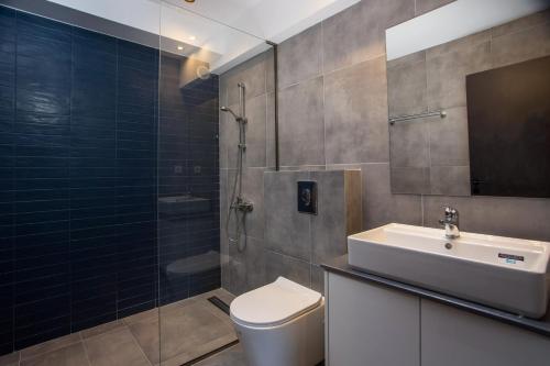 罗德镇VM Apartments的浴室配有卫生间、盥洗盆和淋浴。
