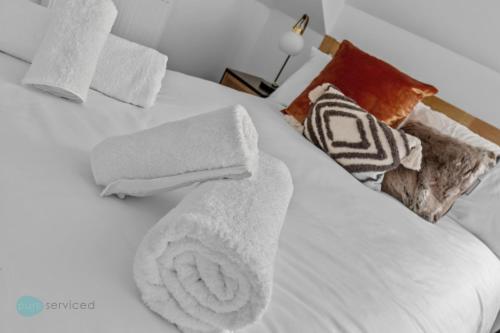 普里茅斯2 Bed- The Penthouse By Pureserviced的白色的床,上面有毛巾