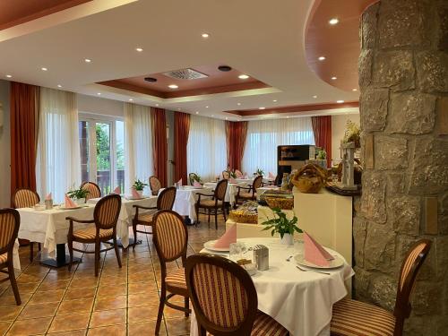 塞扎纳Boutique Hotel Grahor的一间带桌椅和石墙的餐厅