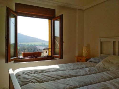 VillatuertaCasa Rural 643km的一间卧室设有两张床和一个美景窗户。