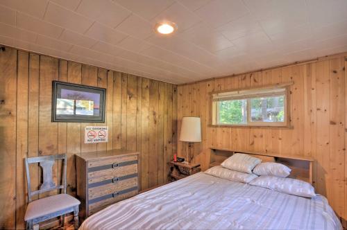 克拉马斯福尔斯Cozy Klamath Falls Home Near Fishing and Parks!的一间带木墙的卧室和一张位于客房内的床