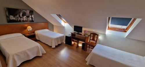 托莱多圣托梅旅馆的客房设有两张床、一张桌子和一个窗户。