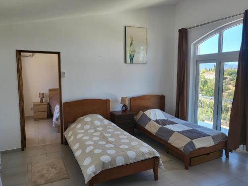 西尔韦斯Villa Madeira的一间卧室设有两张床和窗户。