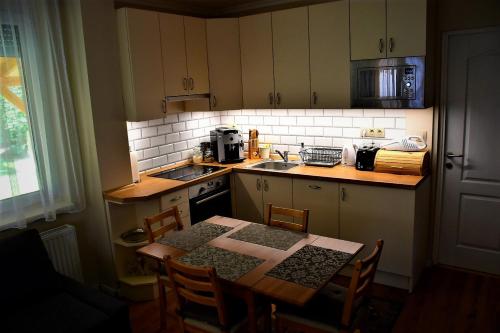 佐洛卡罗斯Kéknefelejcs Vendégház的厨房配有桌椅和台面