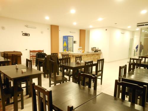 圣萨尔瓦多德朱Parque Hotel的餐厅设有木桌、椅子和柜台