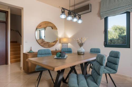 MourniaíAntonia Blue Villa的一间带木桌和蓝色椅子的用餐室