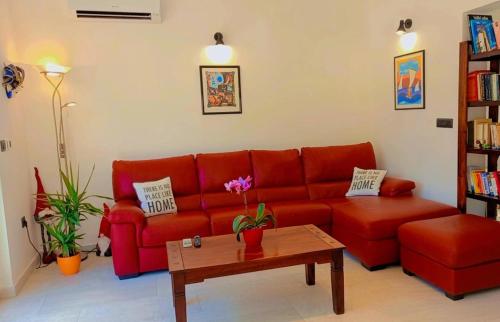利兹扬Casa Alice的客厅配有红色沙发和茶几