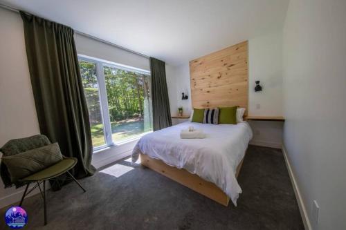 MansonvilleChalet Forestria - SPA- Billard- Ski的一间卧室配有一张大床和一把椅子