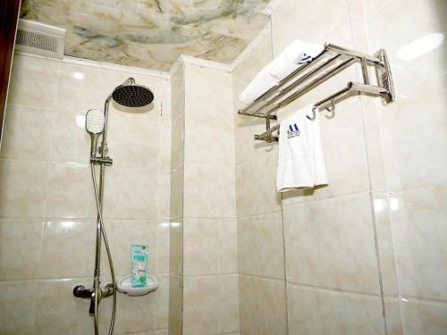 杜阿拉Marriot Metropolitan Hotel的带淋浴、水槽和毛巾的浴室