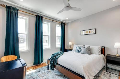 费城Trendy Fairmount Gem-5 star Location, Roof Deck, PARKING, GR8 for FAMILIES的一间卧室配有一张带蓝色窗帘的大床