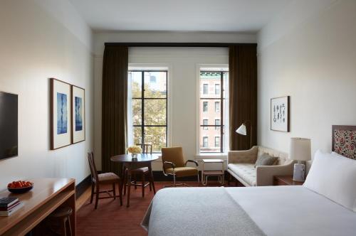 纽约Nine Orchard的酒店客房带一张床、一张桌子和椅子