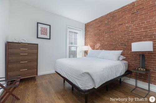 波士顿304 Newbury Street by Thatch的一间卧室设有砖墙和一张床