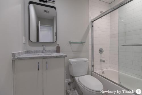 波士顿304 Newbury Street by Thatch的一间带卫生间、水槽和镜子的浴室