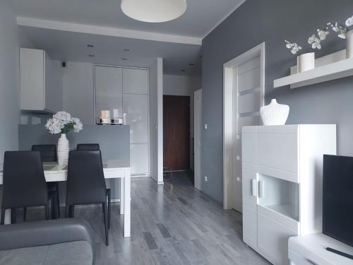 卡托维兹Modern Apartment - Francuska Park的一间配备有白色桌子和黑色椅子的用餐室