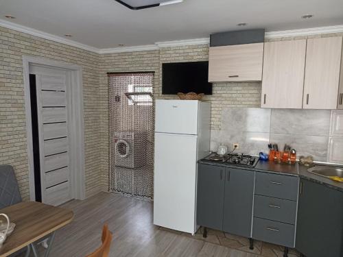 连科兰Частный дом Ленкорань的厨房配有白色冰箱和桌子